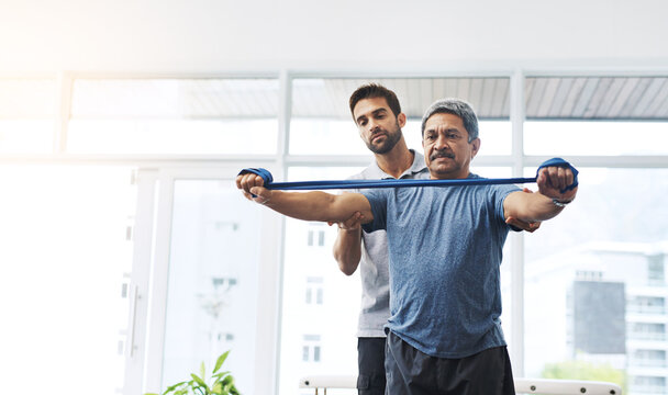 Physiotherapist guiding patient through resistance band rehabilitation exercise